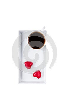 Black coffee in a white cup and two red hearts candy isolated on white background. Happy Valentine`s Day