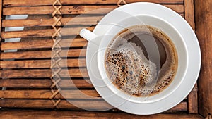 Black coffee in white cup on wooden background