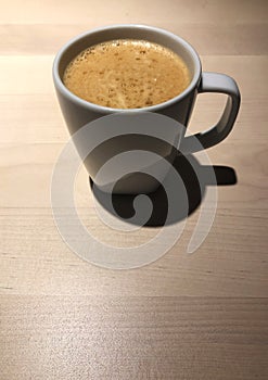 Black coffee in white cup on the wooden table with cafe light. Copy space