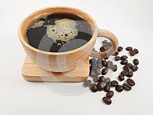 Black coffee in wood cup, coffee beans on old wooden texture background.