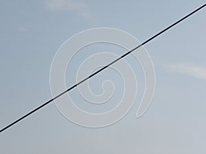 Black color electrical cable on blue sky