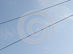 Black color electrical cables on blue sky