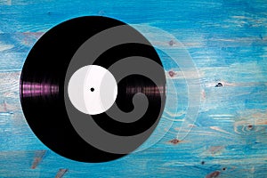 Black color vinyl record on blue wooden background