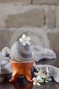 Black colored egg on clay plate. Happy Easter card. Holidays breakfast concept. Festive table place setting decoration