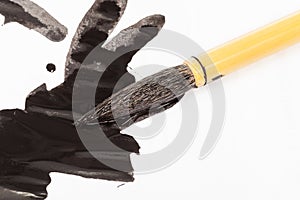 Black colored tip of paintbrush over ink stains