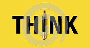 Black colour pencil with word meaning THINK on yelllow background photo