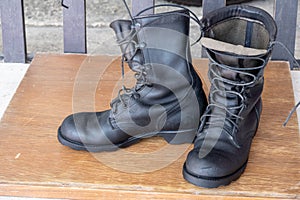 The black combats on a wood floor.