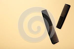Black combs on beige background. Top view
