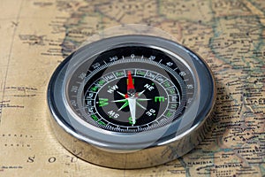 The Black compass on old vintage map, macro background