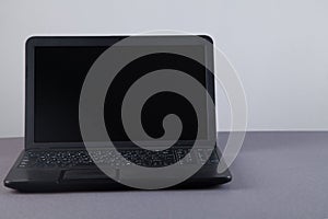 Black computer on gray table with empty screen