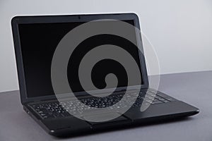 Black computer on gray table with empty screen