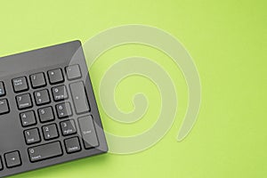 Black computer keyboard on a green background