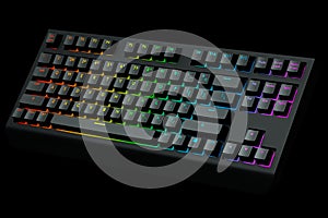 Black computer keyboard with rgb colors isolated on black background.