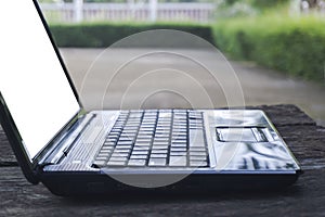 Black computer laptop or notebook empty on a wood table with a black screen mockup, concept technology work form home and distance