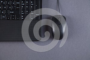 Black computer and mouse on gray table with empty screen