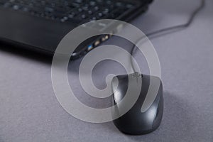 Black computer and mouse on gray table with empty screen