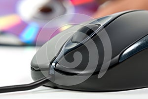 Black computer mouse and optical data disc in back