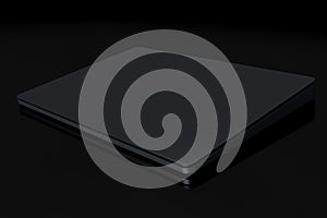 Black computer trackpad or wireless touch pad isolated on black background photo