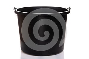 Black construction plastic bucket with a metal handle on a white isolated background