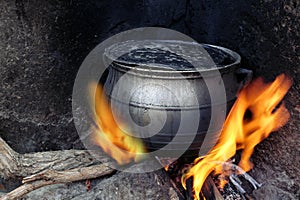 Black coocking pot heated on fire photo