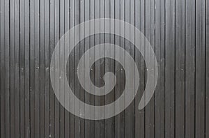 Black corrugated metal surface. real image of a used gate. industrial style background