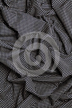 Black cotton fabric with white dots design texture. Overlapping strips. Background.