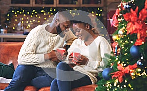 Black couple celebrating Christmas together, reading coffee grounds for fun