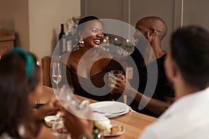 Black couple, champagne and party celebration with friends for new years, Christmas or social holiday event dinner at