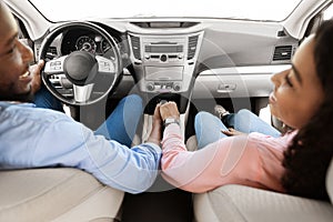 Black couple enjoying drive on car, holding hands