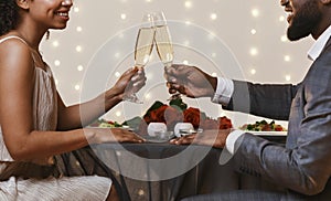 Black couple having date at restaurant, toasting with champagne