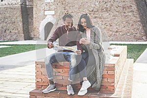 Black couple looking city map app during vacation tour - Happy african people having fun in down town center - Travel, love and