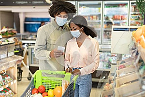 Black Couple Shopping Groceries Using Smartphone Application In Store