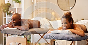 Black couple, spa massage and happiness on a table for luxury, zen and relax together at a health and wellness salon