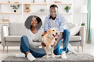 Black couple spending time at home with dog