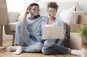 Black Couple Using Laptop Sitting On Floor In New Apartment