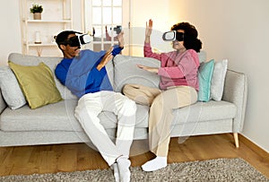 Black Couple Wearing VR Headsets Playing Virtual Game At Home