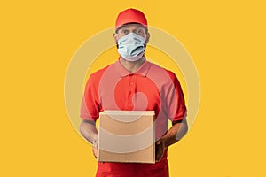 Black Courier Guy Delivering Cardboard Box Wearing Mask, Yellow Background