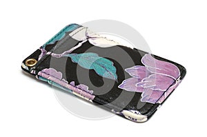 A black credit card holder pouch with pink green leaves printing white backdrop