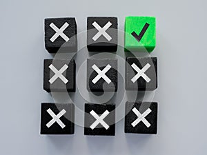 Black cubes and one green as concept for errors and correct answer or solution.