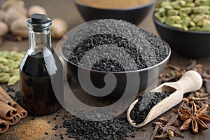 Black cumin seeds and oil bottle, aromatic spices on table. Ingredients for cooking. Ayurveda treatments