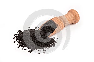 Black cumin seed in wooden scoop isolated on white background. Top view, Nigella sativa