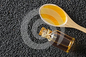 Black cumin seeds essential oil , Nigella Sativa in spoon on heap of black cumin