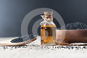 Black cumin seeds essential oil , Nigella Sativa in spoon on wooden background