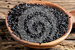 Black cumin seeds on a wooden spoon on a table