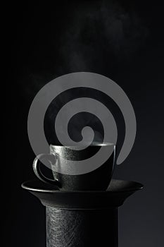 Black cup of coffee on a black background
