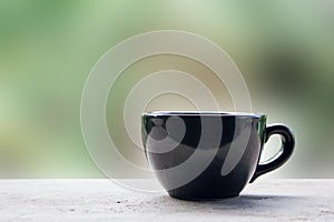 Black cup of coffee or tea on table