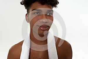 Black curly sportsman with towel looking away