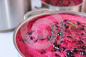 black currant berry, boiled in a saucepan on the stove.