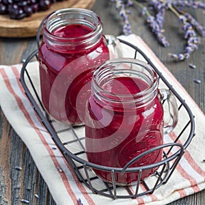 Black currant, greek yogurt, honey and lavender smoothie in glass jar, square format