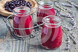 Black currant, greek yogurt, honey and lavender smoothie in jar with berries and flowers on background, horizontal